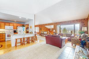 een keuken en woonkamer met een bank en een tafel bij Wapiti Point - Main House in Grand Lake