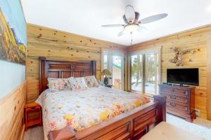 een slaapkamer met een bed en een flatscreen-tv bij Wapiti Point - Main House in Grand Lake