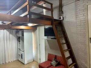 a loft bed in a room with a tv at Pousada dos Pássaros in Gramado