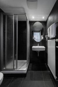 czarno-biała łazienka z prysznicem i umywalką w obiekcie My Hotel Apollon w Pradze
