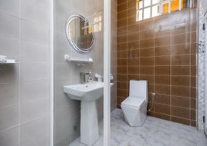 Un baño con lavabo, inodoro y espejo. en magnifique appartement, de deux balcons, très spacieux, en Baguida 15 fotos más