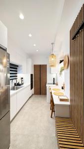 a kitchen with white cabinets and a dining table at Angel Syros Luxury Apartment in Ermoupoli