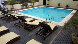 a pool with chaise lounge chairs and a swimming pool at Howard Johnson by Wyndham San Pedro in San Pedro +23 photos