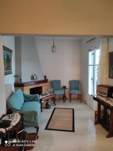 a living room with blue chairs and a fireplace at Diktynna Villa in Palekastron