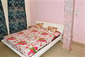 a bedroom with a bed with pink flowers on it at Immeuble gold in Bamako