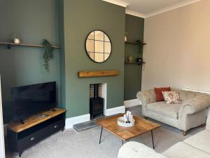 Una sala de estar con un sofá y un televisor. en Amber House Retreat, en Saltburn-by-the-Sea