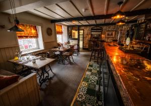 a restaurant with tables and chairs and a bar at Queen's Head Askham in Penrith