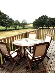 a table and four chairs on a wooden deck at Little gem at foot of Malvern Hills in Great Malvern