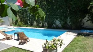 a swimming pool with a table and a chair next to it at Chill Inn Hostel in Mendoza