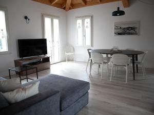 a living room with a couch and a table and chairs at Il Colle Apartments in Bellagio
