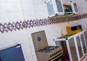 a small kitchen with a stove and a sink at Très beau logement à Baguida in Lomé +4 photos