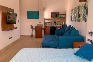 a living room with a blue couch and a kitchen at Departamento nuevo moderno tipo estudio in La Paz
