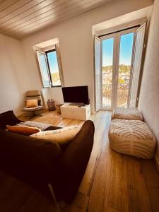 a living room with a couch and a large window at Casa do Castelo in Belver