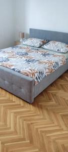 a bed sitting on top of a wooden floor at Apartman Car in Vir