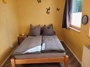 a bed in a room with yellow walls at Ferienwohnung mit Garten - 10 Minuten von Templin in Milmersdorf +14 photos