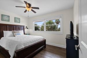 ペンサコーラ・ビーチにあるSunny Daze Beach Houseのベッドと天井扇風機のある寝室 +39枚の写真