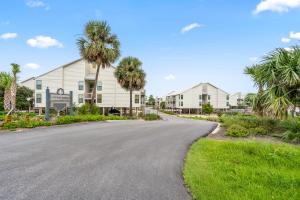 a road in front of a building with palm trees at Cotton Bayou Unit 4E in Orange Beach