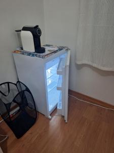 a small white table with a refrigerator in a room at House Prosperity in Amora