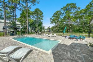 a swimming pool with lounge chairs and a pool table at Bayside Bliss in Pensacola