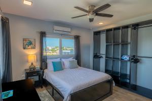 a bedroom with a bed with a ceiling fan at The Lor-E-Lei House in San Pedro +22 photos