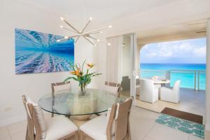 a dining room with a glass table and a view of the ocean at Beachcomber 33 in George Town