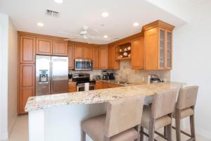 a kitchen with wooden cabinets and a granite counter top at Beachcomber 33 in George Town