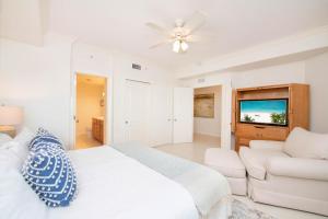 a white bedroom with a bed and a couch at Beachcomber 33 in George Town +33 photos