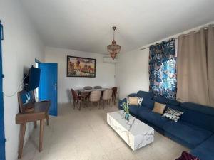 a living room with a blue couch and a table at Villa Djerba Arkou in Djerba