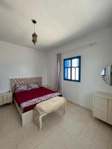 a bedroom with a red bed and a window at Villa Djerba Arkou in Djerba +13 photos