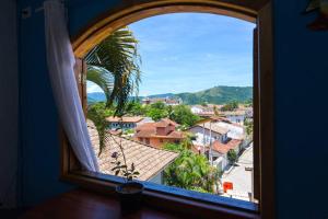 an open window with a view of a city at SunriseBelaVista Pousada e Flats in Paraty
