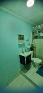 a bathroom with a white toilet and a sink at Hospedagem da Família hostel in Cabo Frio