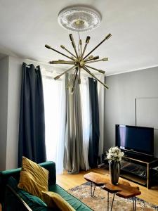 a living room with a green couch and a chandelier at Apartment-City in Cologne