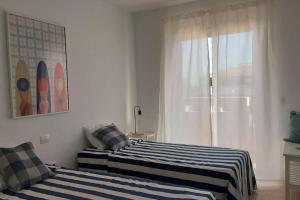 a bedroom with two beds and a window with at RdG Home in Puertito de Güímar