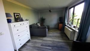 a living room with a couch and a white dresser at Ferienwohnung Hänel in Römstedt