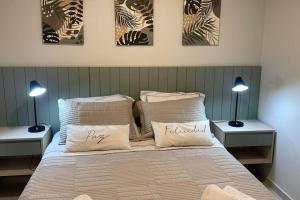 a bedroom with a bed with three pictures on the wall at Departamento Home Ycua Sati in Asunción