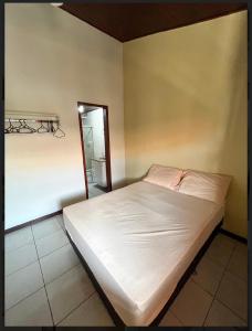 a white bed in a room with a table at Praia das Dunas Residence Club in Cabo Frio