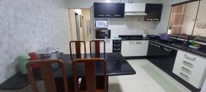 una cucina con tavolo nero e sedie di Casa de praia toda mobiliada na primeira quadra da ilha de Guriri São Mateus ES a São Mateus Altre 22 foto
