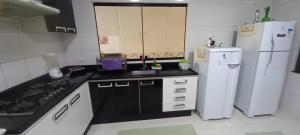 una cucina con un frigorifero bianco e un lavello di Casa de praia toda mobiliada na primeira quadra da ilha de Guriri São Mateus ES a São Mateus
