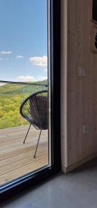 a bench sitting on a deck looking out a window at Porta Bungalows in Rudnik