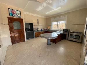 a large kitchen with a table in the middle of it at Villa Safaa Dar Bouazza in Dar Mouddene