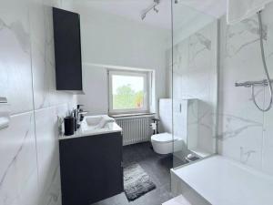 ein weißes Badezimmer mit Waschbecken und Toilette in der Unterkunft Charming 5bedroom Home with gym,garden,parking&terrace-HOL15 in Luxemburg (Stadt) + 13 Fotos