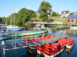 two boats are docked at a dock in the water at Apartment near Lake Radunskie in Stezyca in Stężyca