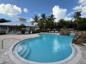 a swimming pool with blue water in a yard at Spacious 2BR Lely Resort Condo with Lake View steps to Pool Hot Tub Gym in Naples