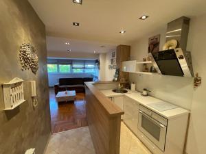a kitchen with a sink and a living room at Comfy & Cozy Apartment - parking in Karaburma