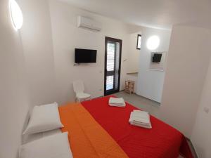 a white room with a bed with a colorful blanket at Casa Borgo Antico Cavallaro in Gaggi +25 photos