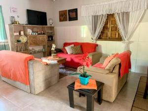 a living room with two couches and a red couch at Casa de campo Maria&Maria próximo a cidade de Juiz de Fora MG in Juiz de Fora