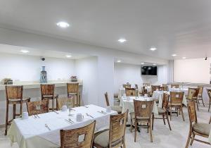 a dining room with tables and chairs and a screen at Olmeca Plaza Urban Express in Villahermosa