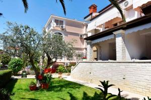 duży biały dom z podwórkiem z trawą i budynkiem w obiekcie Apartments in Porec - Istrien 40311 w Poreču