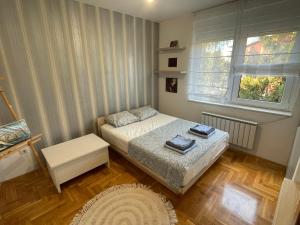 a small bedroom with a bed and a window at Comfy & Cozy Apartment - parking in Karaburma