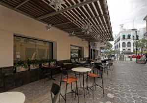 un restaurant avec des tables et des chaises dans une rue dans l'établissement Olmeca Plaza Urban Express, à Villahermosa
